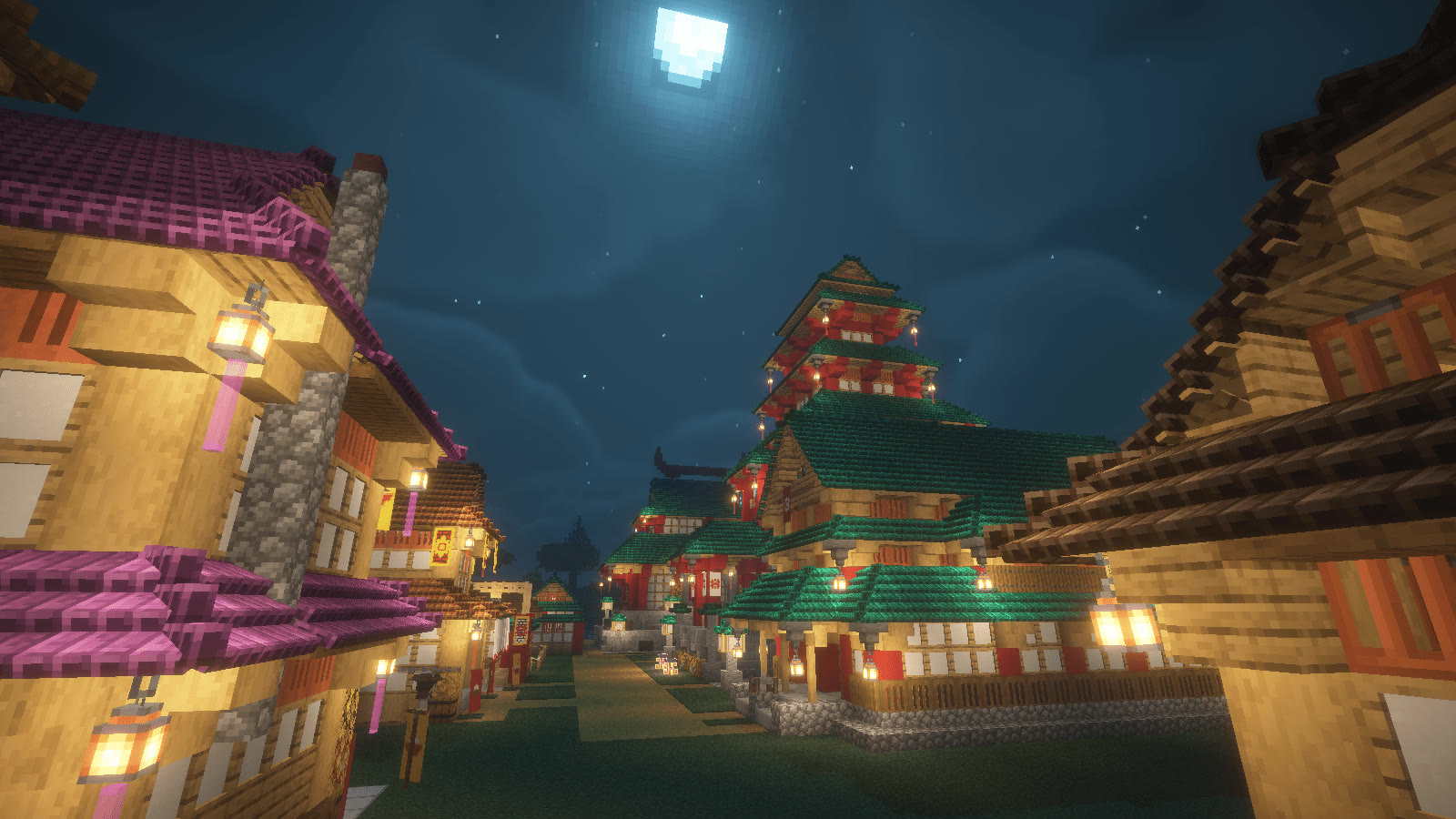 An All the Mods 10 player-built village at night, showing the scale and detail typical of long-running ATM10 servers